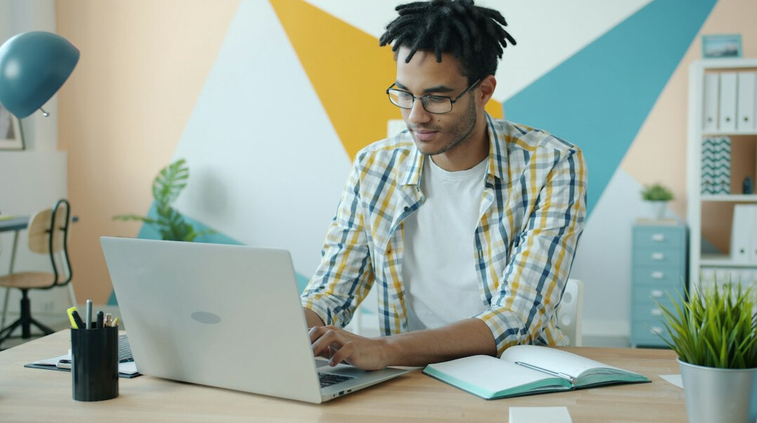man writing email at desk